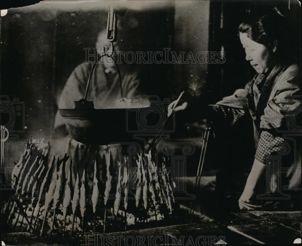 1927 Press Photo Japanese woman drying fish around a fire - Historic Images