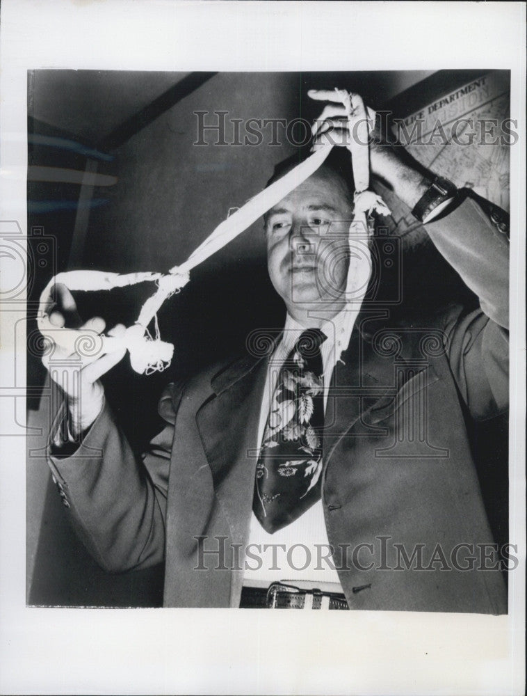 1950 Press Photo Detective Jack Gladstone inspecting a Noose used for suicide. - Historic Images