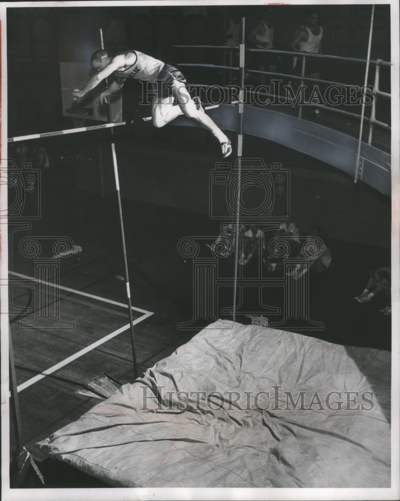 1958 Marquette pole vaulter Ed Hoyle clears the bar in tight corner - Historic Images