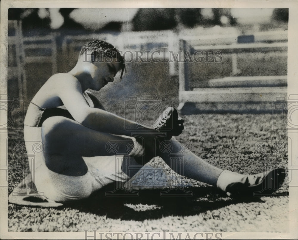 1935 Press Photo Philip fixes spikes on shoes before high jump in 1935 - Historic Images