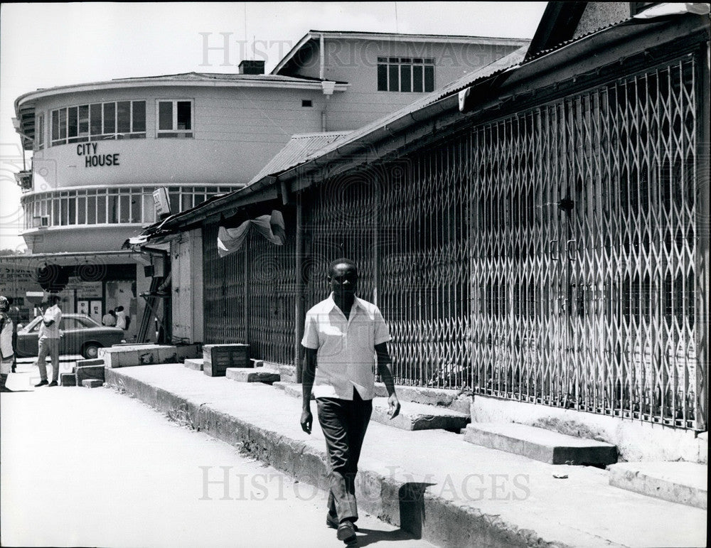 Press Photo Man Walks Past Closed Asian Shop - KSB27551