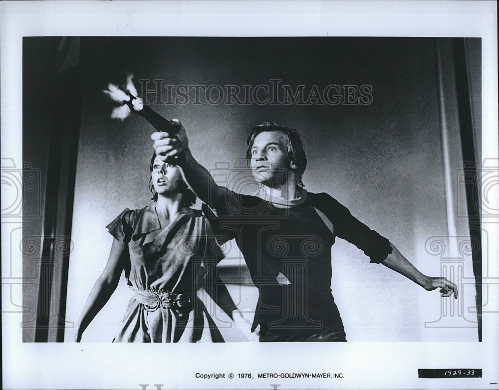 1976 Press Photo A Man Fires From A Gun As A Woman Watches- Historic Images