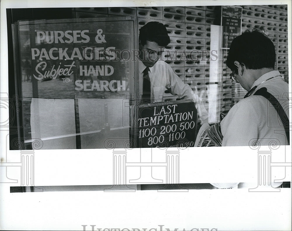 1988 Press Photo &quot;Last Temptation Of Christ&quot; Film-Goer Buys Ticket With Security- Historic Images