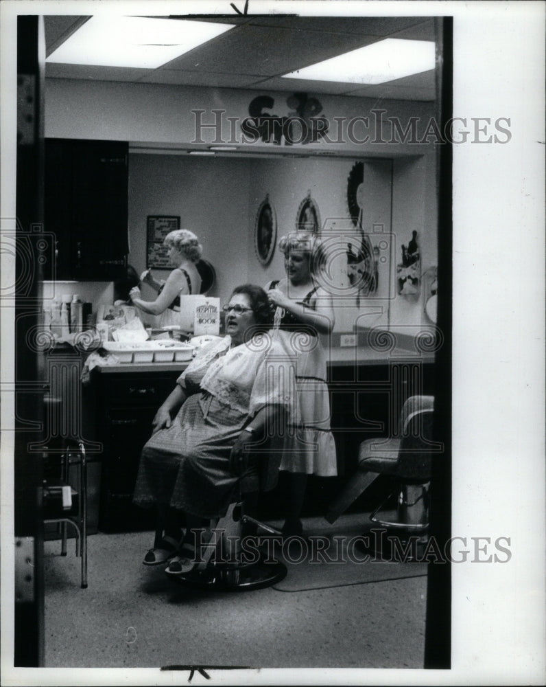 1980 Blonde cutting hair in a salon - RRU57109- Historic Images