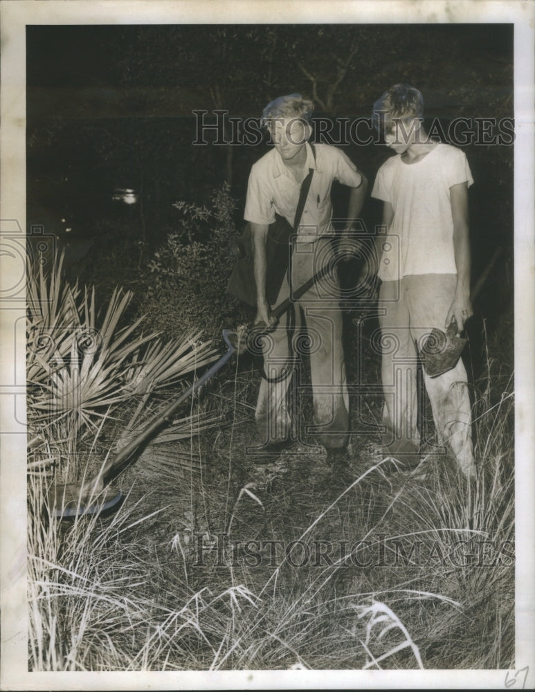 1950 Press Photo Two men white dresses one bag hang sti- Historic Images