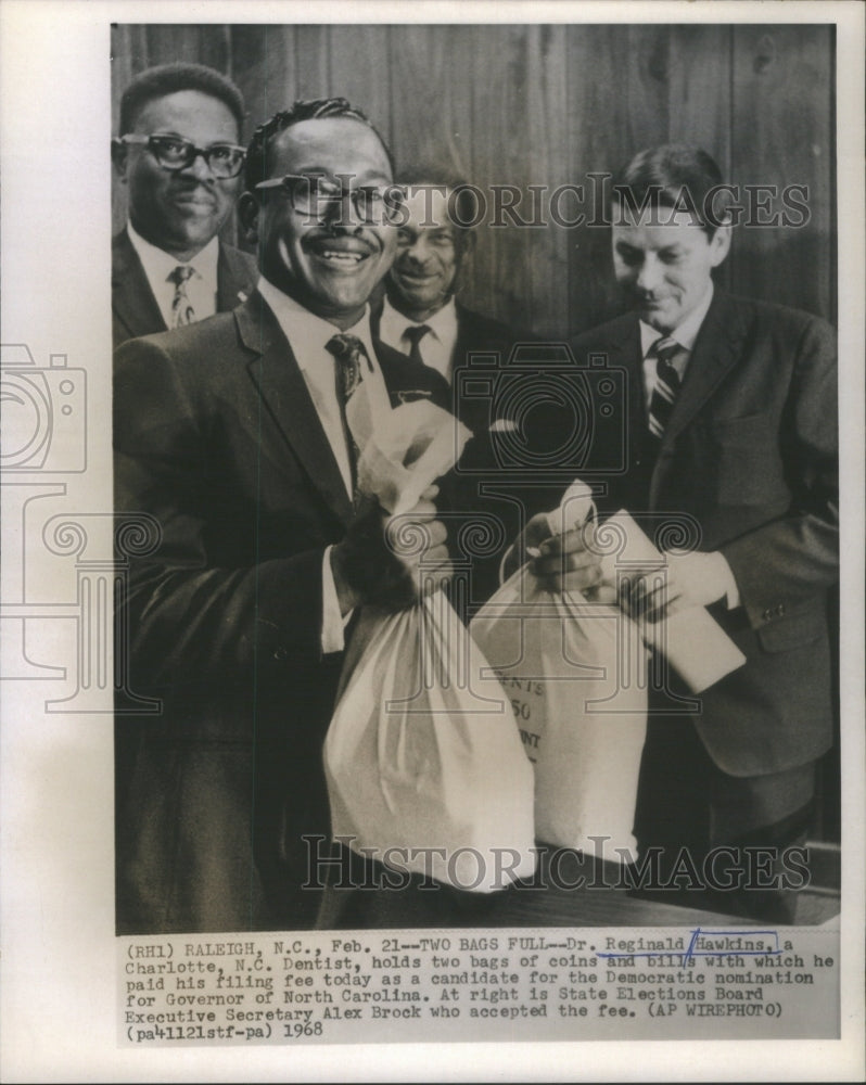 1968 Press Photo Dentist Dr Reginald Hawkins Charlotte two bags coins bills Paid- Historic Images