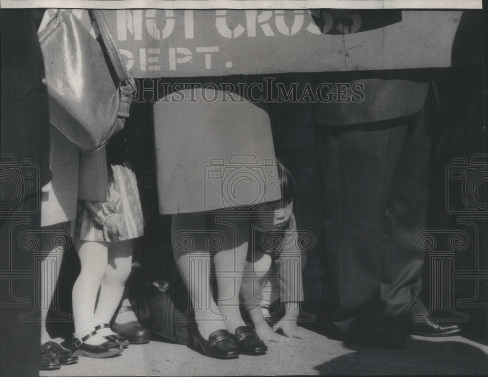 1975 Press Photo Little girl crouches under barricade- RSA77269- Historic Images
