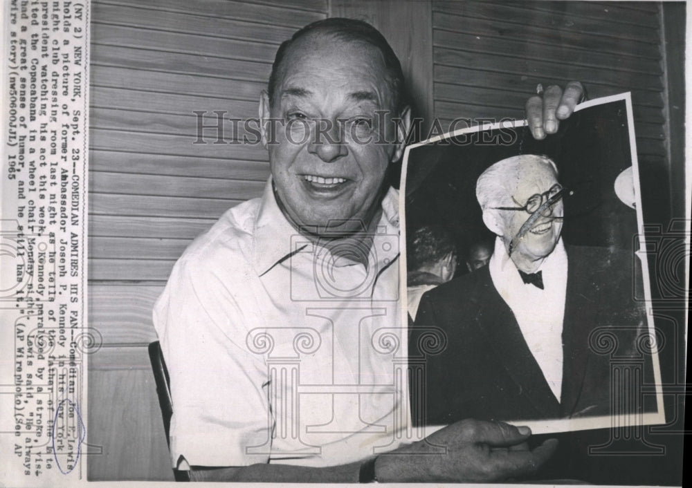 1965 Press Photo Comedian Joe Lewis hols a photo of Ambassador Joseph Kennedy.- Historic Images