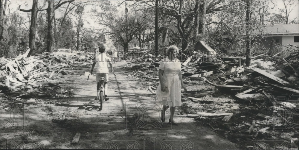 1969 Press Photo Amy Walker walks down lonely street now covered with rubble- Historic Images