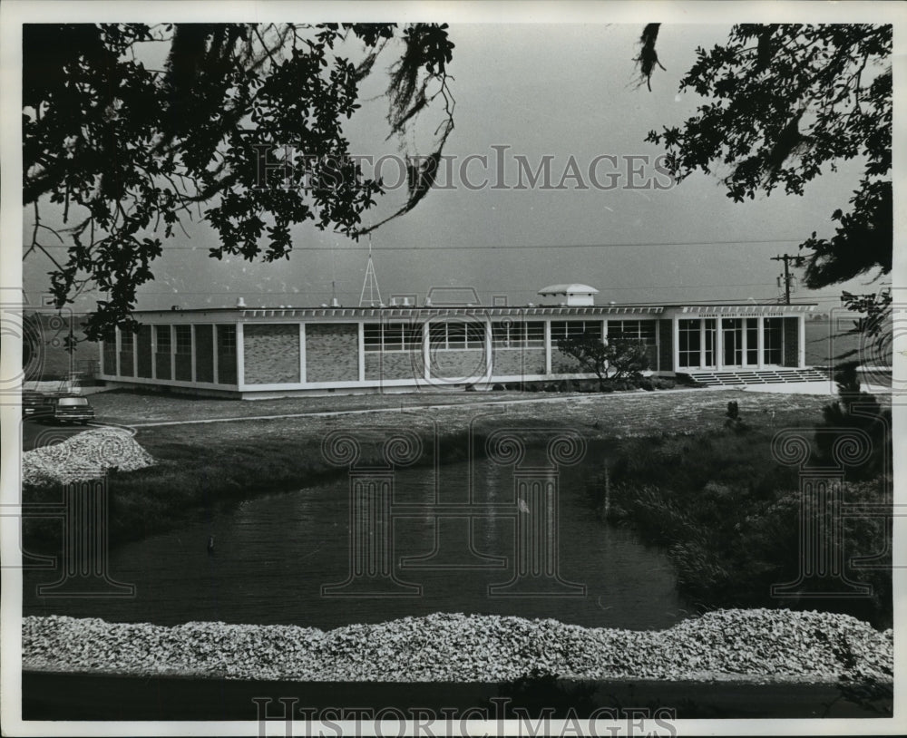 Press Photo Building alongside a small body of water - abna23236