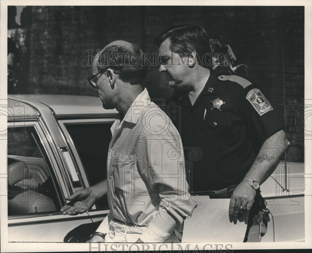 Press Photo William Slagle escorted to car by police officer - abna41225