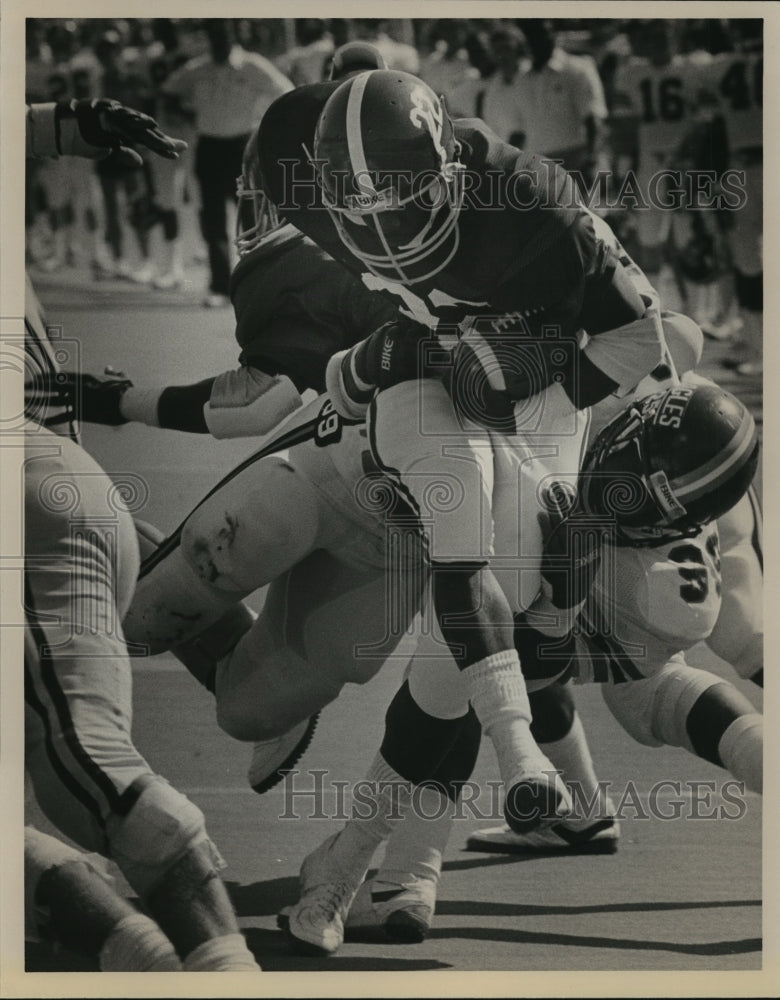 1986 Press Photo Alabama #22 Gene Jelks is tackled by SMU #99 Sidney Coleman. - Historic Images