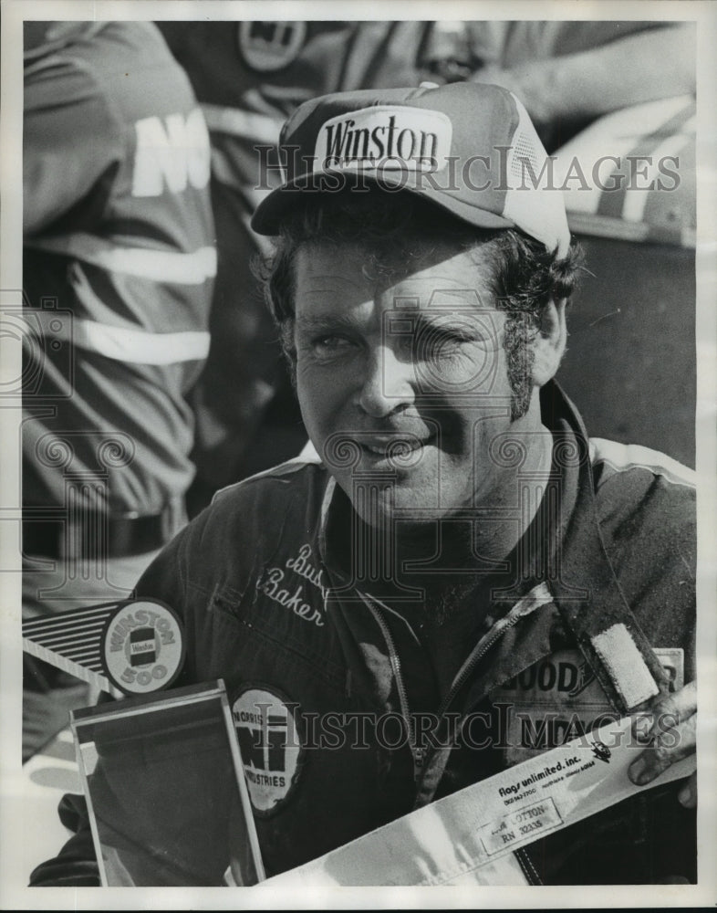 1976 Press Photo Race car driver, Buddy Baker holds winning checkered flag. - Historic Images