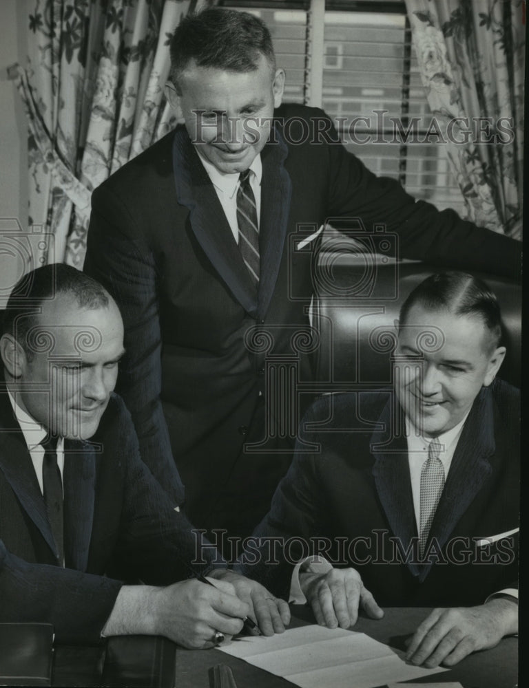 1963 Press Photo Signing in Howard&#39;s new coach, Alabama- Historic Images