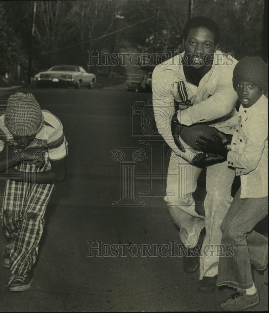 1977 Press Photo Jeffrey Patterson hands football to Alabama Charlie Williams - Historic Images