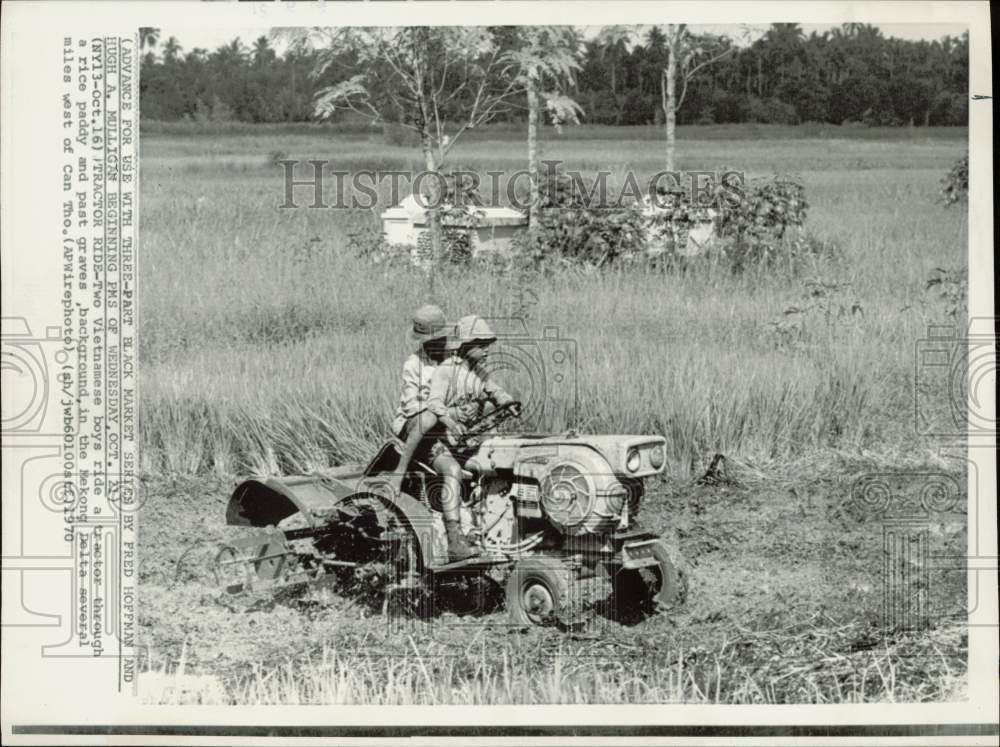 1970 Press Photo Vietnamese Boys Ride Tractor through Rice Paddy/Graves, Vietnam - Historic Images