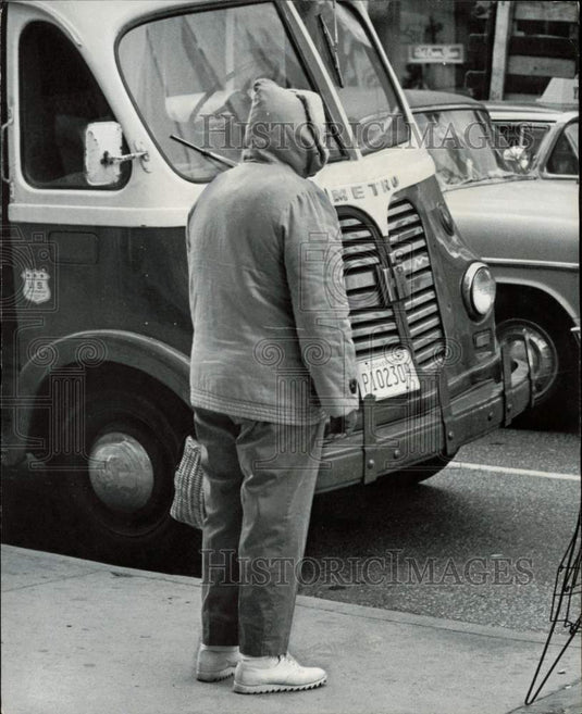 Press Photo Man at Miami bus stop wearing a coat against the cold - afa18442 - Historic Images