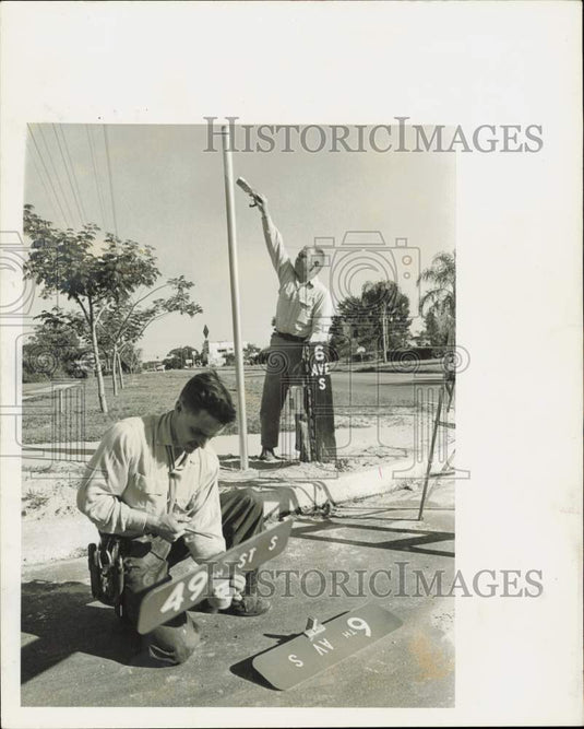 1982 Press Photo Harley Rhodes and Barry Hildabrand set up sign on street corner - Historic Images
