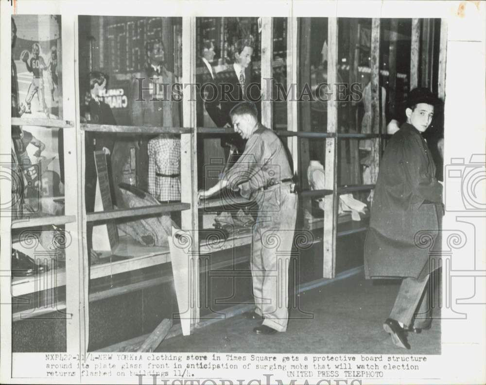 1952 Press Photo Men installing a wooden shield at Time Square, New York store - Historic Images