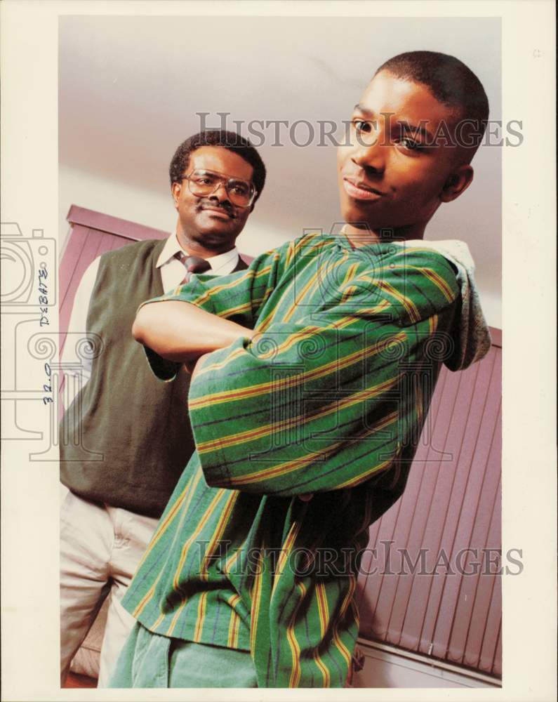 1993 Press Photo Teen models green and yellow striped hooded shirt beside father - Historic Images