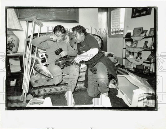 1991 Press Photo Joey Beltran and Daniel Nelson open gift of toy race car - Historic Images