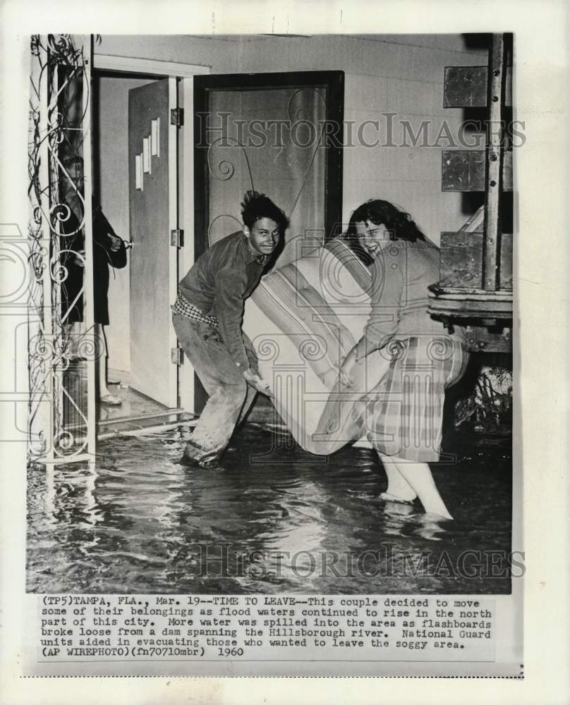 1960 Press Photo Couple moves furniture as flood waters rise in Tampa, Florida- Historic Images