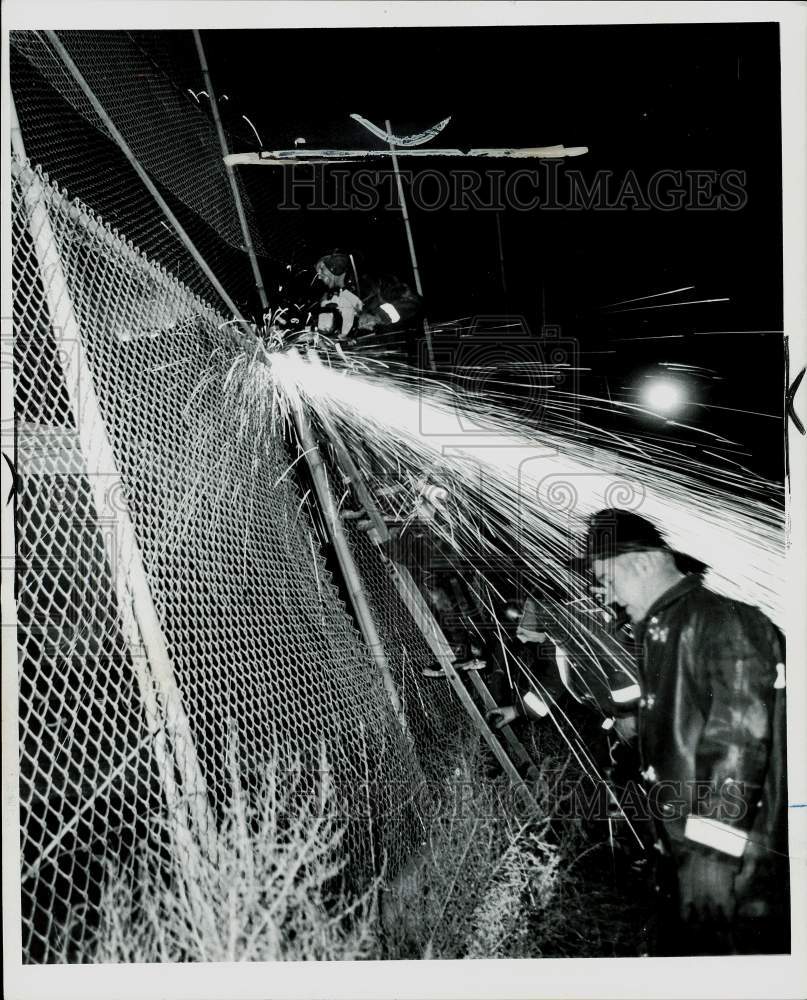 1972 Press Photo Firemen cut fence to access fire at Scripps School Detroit MI - Historic Images