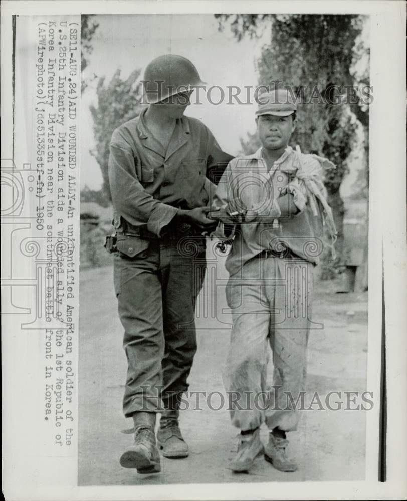 1950 Press Photo An unidentified American soldier aids a wounded ally in Korea - Historic Images