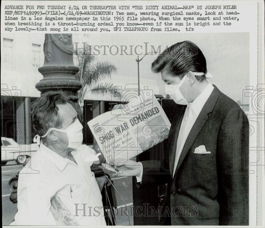 1965 Press Photo Men in surgical masks read a Los Angeles newspaper headline - Historic Images
