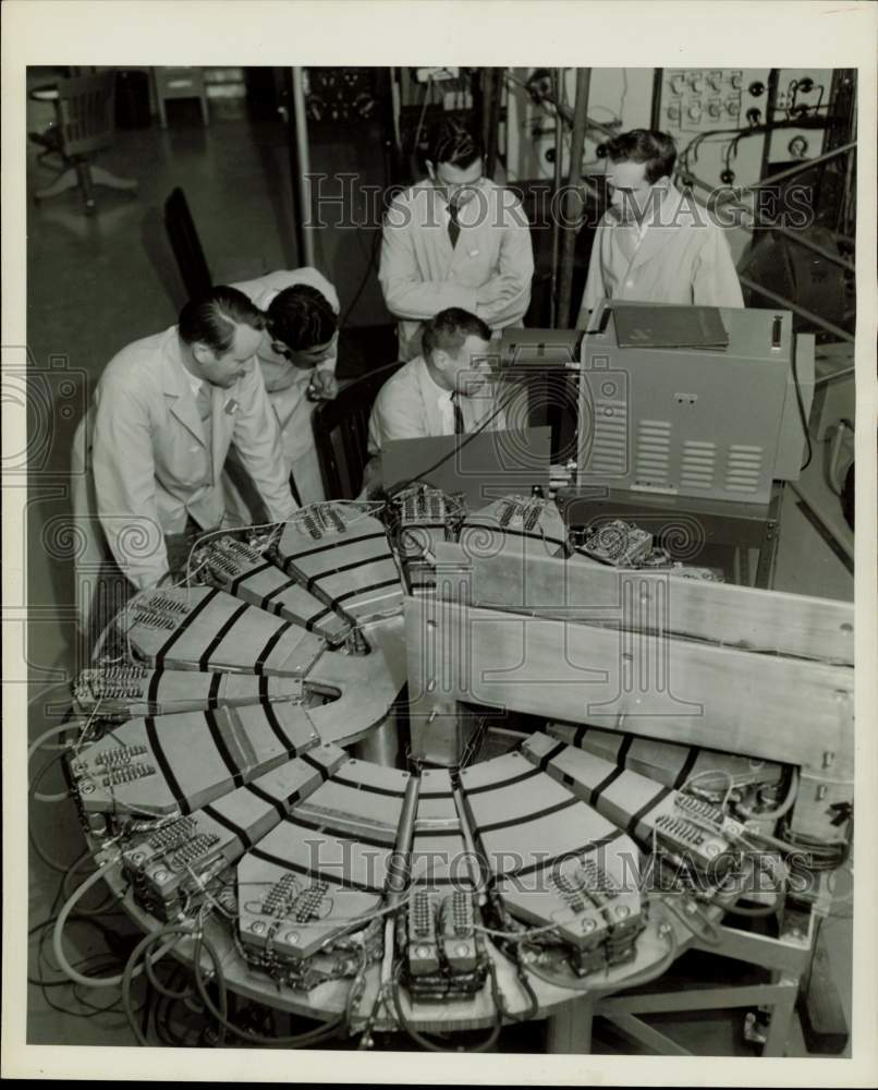 1957 Press Photo Scientists work with a model of the &quot;Synchrocrash&quot; - afx21056 - Historic Images