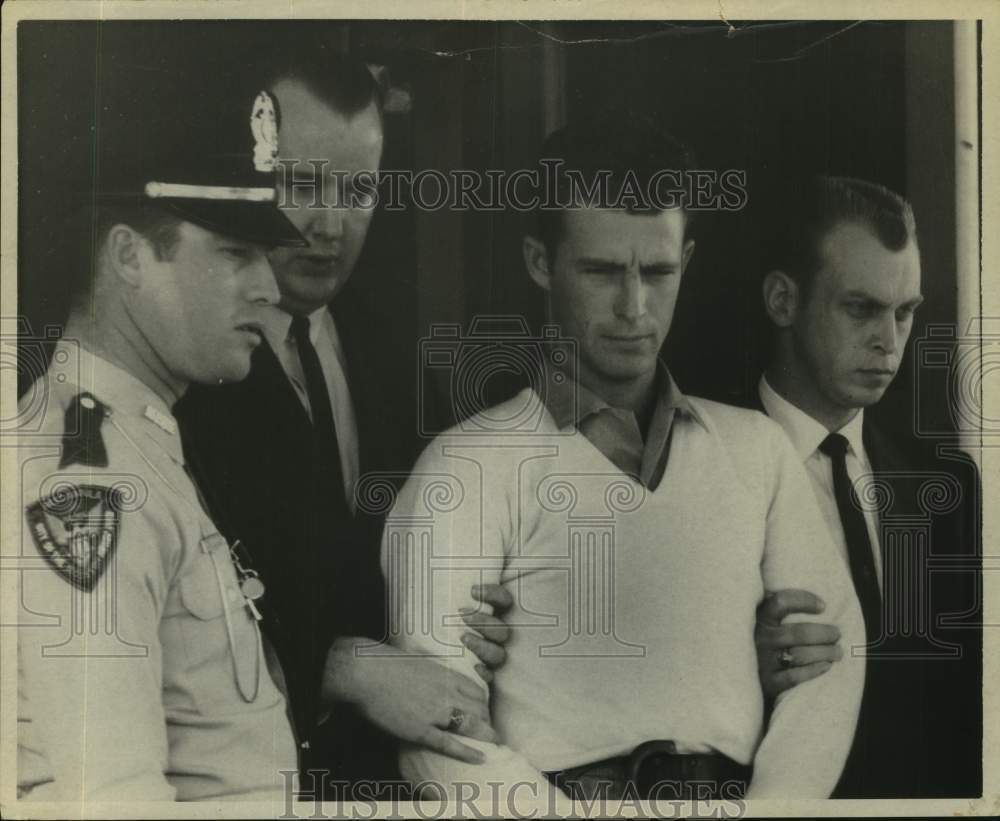 Press Photo Phillip Yates escorted by men in suits as uniformed man watches- Historic Images