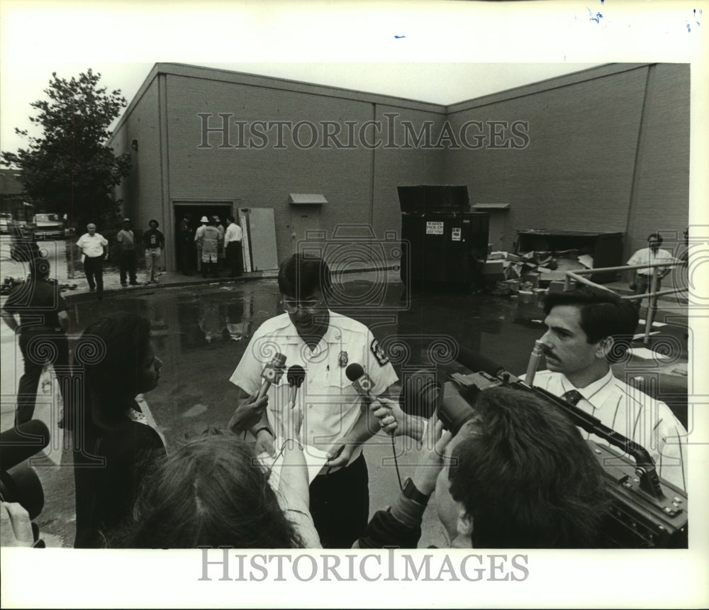 1990 Press Photo Firefighter talks to press by building in Alabama - Historic Images