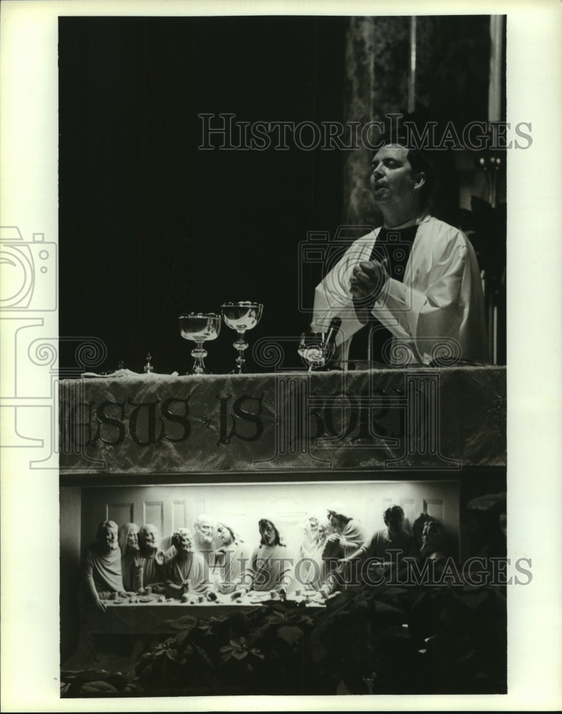 1990 Press Photo Father John Amos offers communion in Alabama church- Historic Images