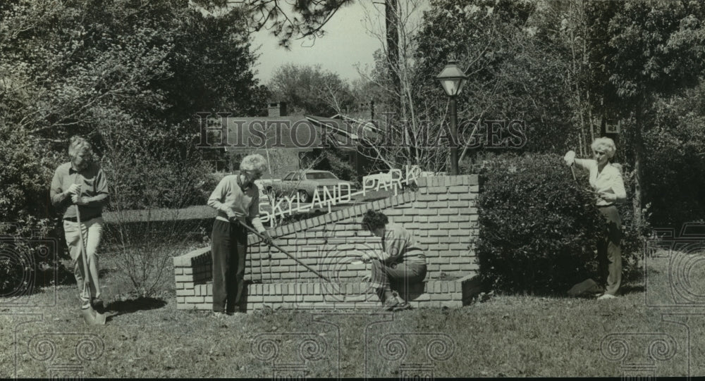 1987 Press Photo Women plant landscaping by Skyland Park sign in Alabama- Historic Images