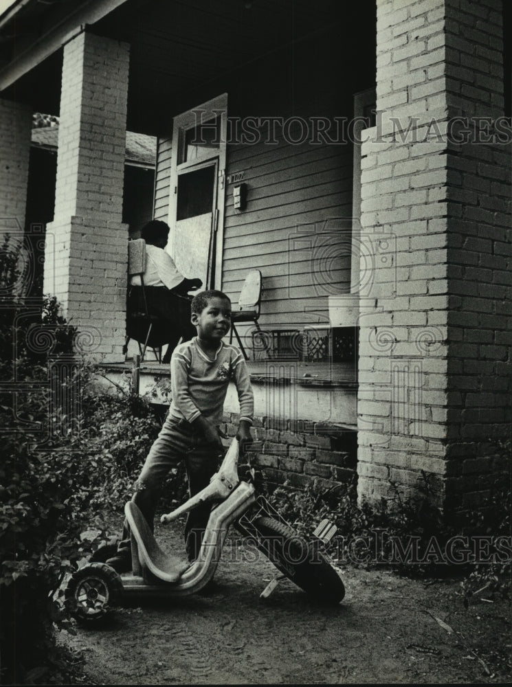 1986 Press Photo Boy by tricycle by Davis Avenue home in Alabama - amra03184- Historic Images