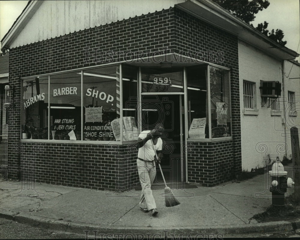 1986 Press Photo Man Sweeping in Front of Barber Shop on Davis Avenue, Alabama- Historic Images