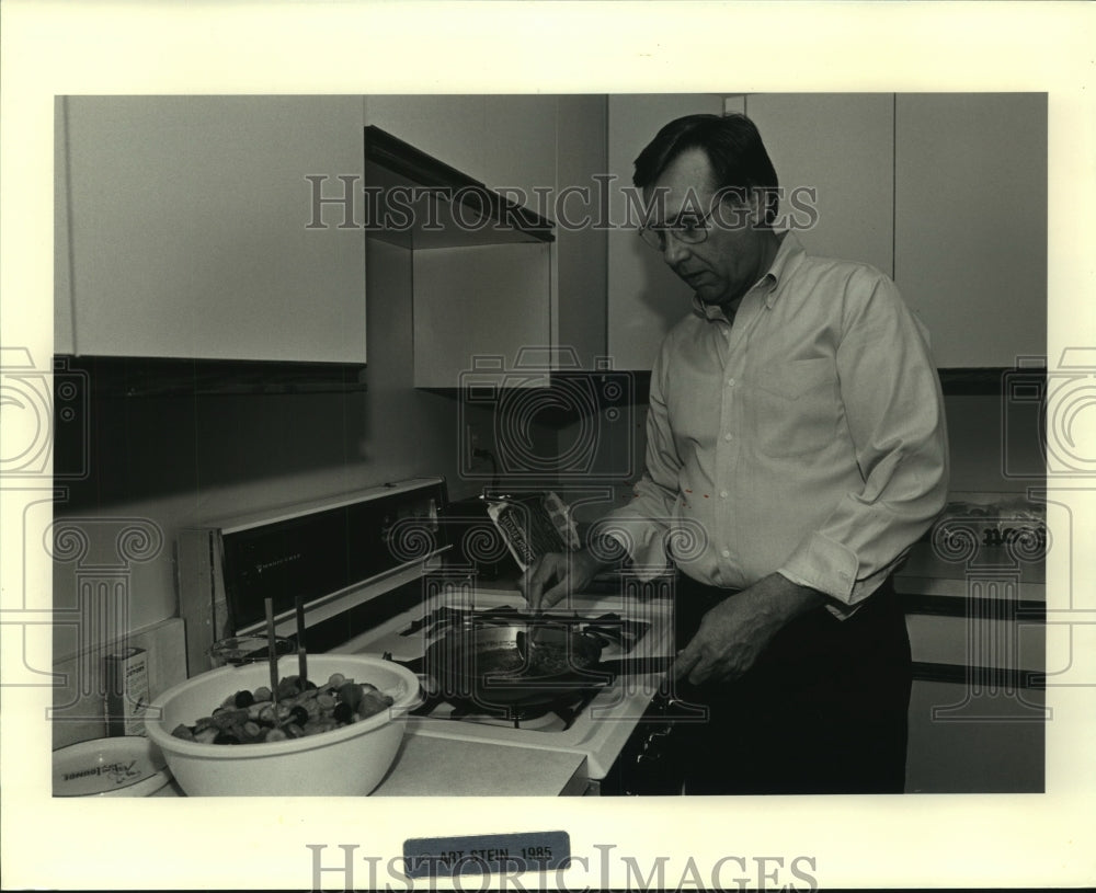 1985 Press Photo Sonny Callahan cooking at his Crystal City, Virginia apartment- Historic Images