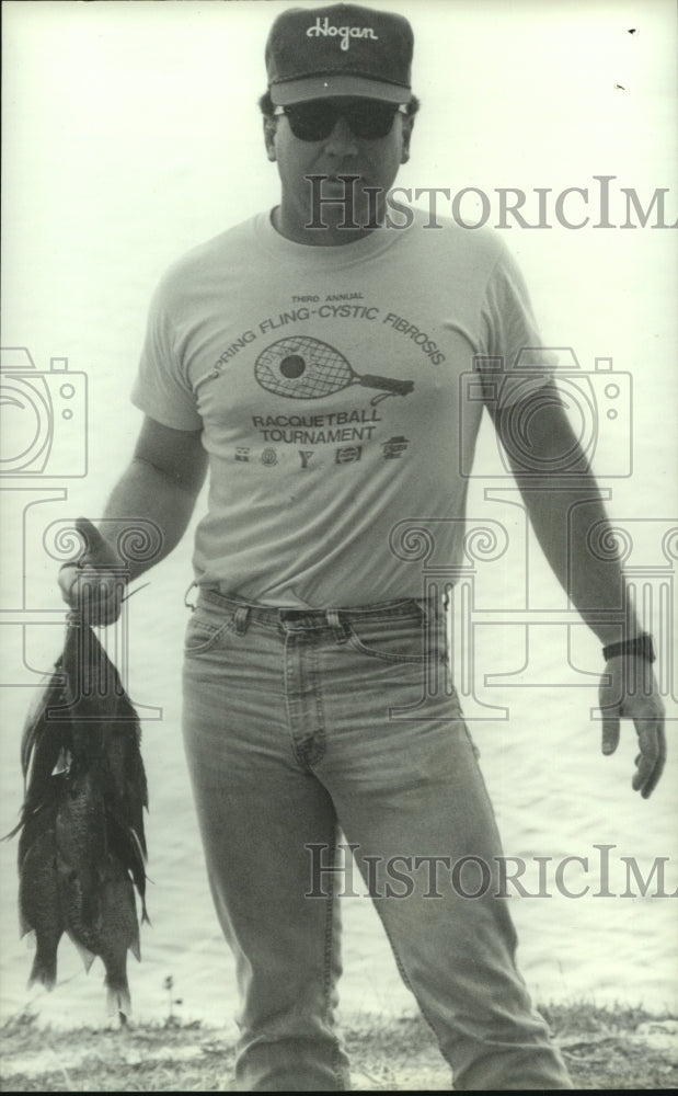 1988 Press Photo Fisherman displaying his catch, Healing Springs, Alabama- Historic Images