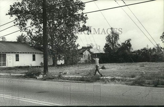 1986 Press Photo A man walking down Davis Avenue, Mobile, Alabama- Historic Images