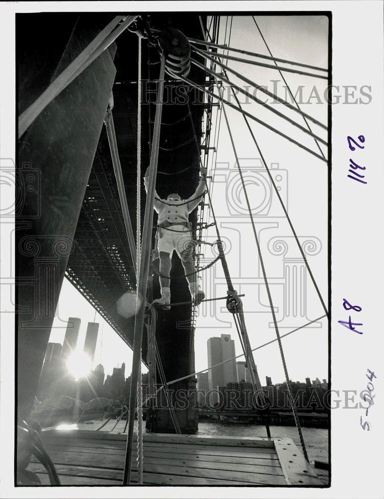 Press Photo Man climbs ropes under bridge - ctca06292- Historic Images