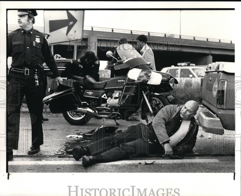 1985 Press Photo Off Duty Cleveland Police Officer Waits for Ambulance transport after crash Robert - Historic Images