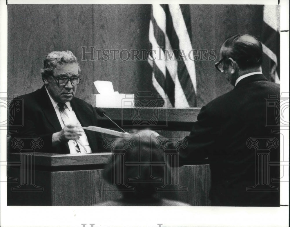 1991 Press Photo Norbert G. Dennell Jr. examines documents presented to him - Historic Images