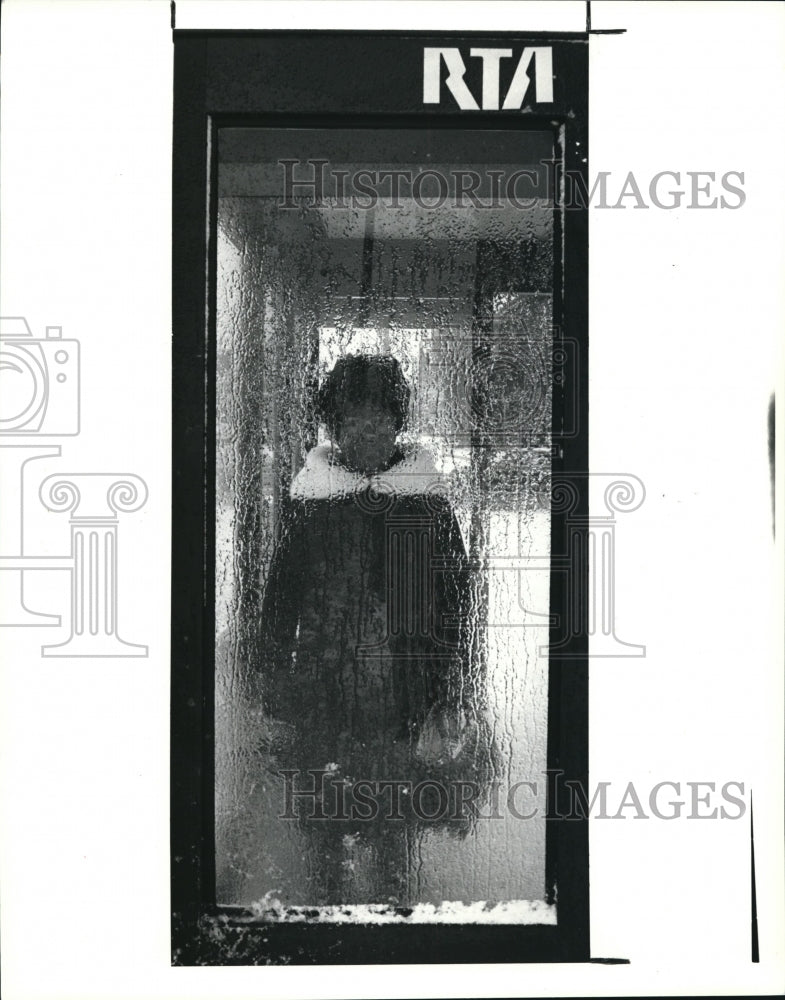 1990 Press Photo Peeping through an icy covered window of a RTA bus shelter at- Historic Images