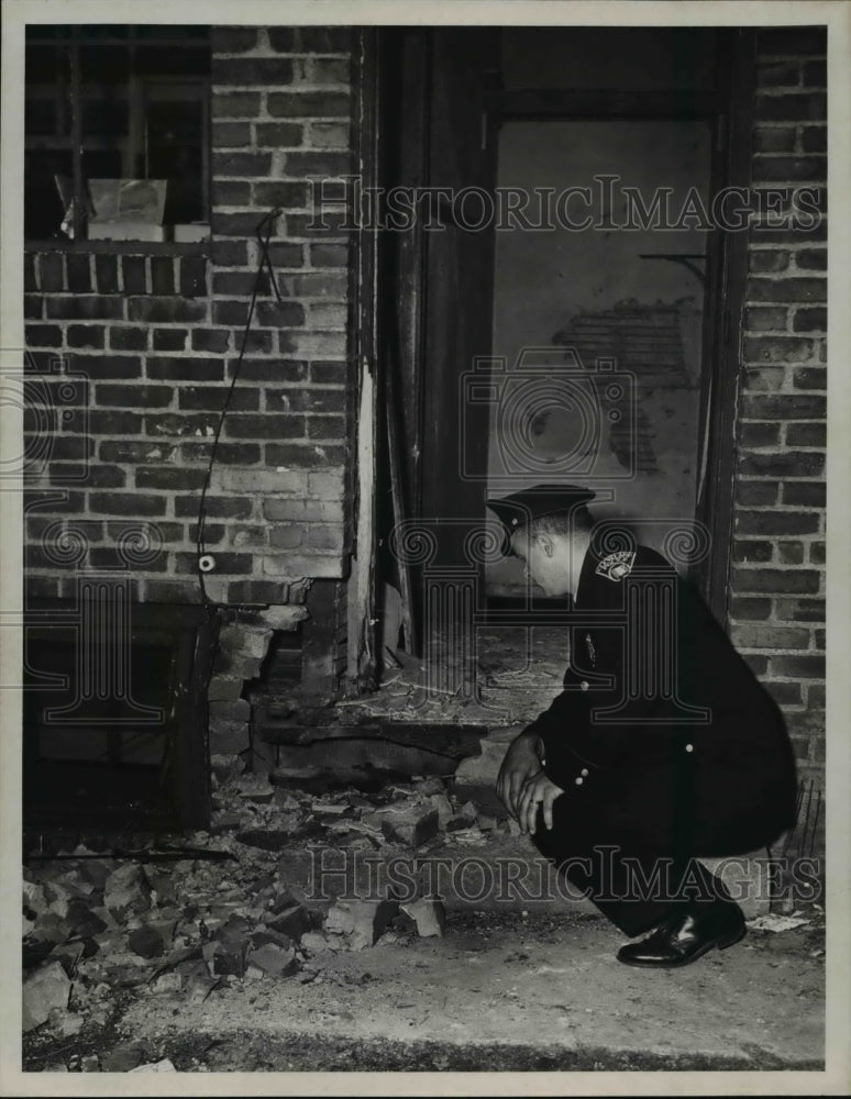 1953 Press Photo Patrolman John Kukula looks at spot where bomb was placed- Historic Images