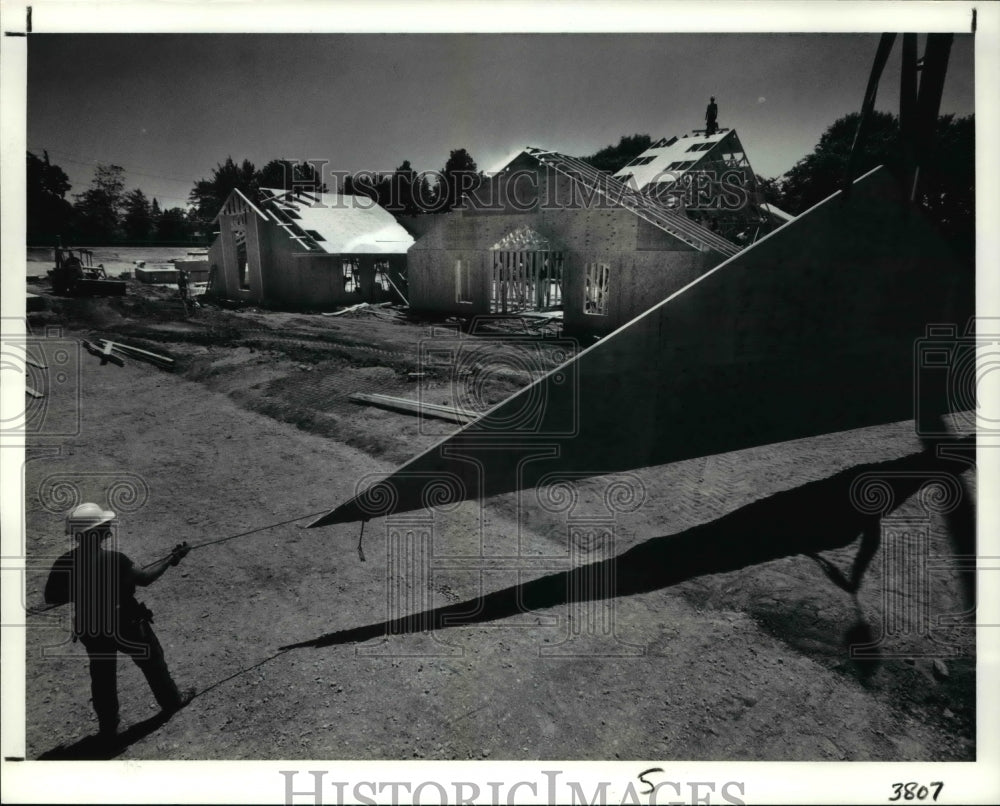 1991 Press Photo Johnny Walker helps guide the end of the roof piece- Historic Images