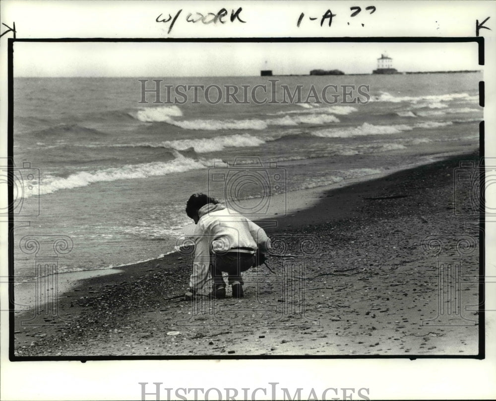 1985 Press Photo Little girl cleaning Mentor Headlands Beach- Historic Images