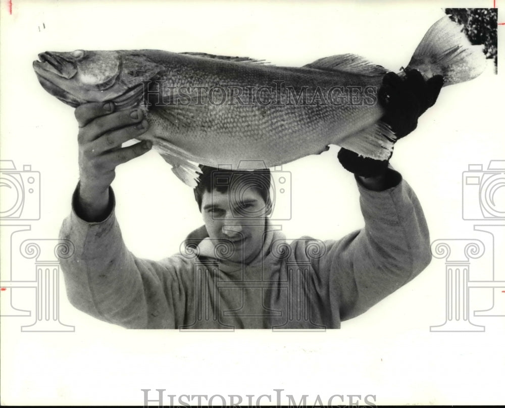 1986 Press Photo Scott Kaib hefts a walleye whopper he caught through the ice- Historic Images