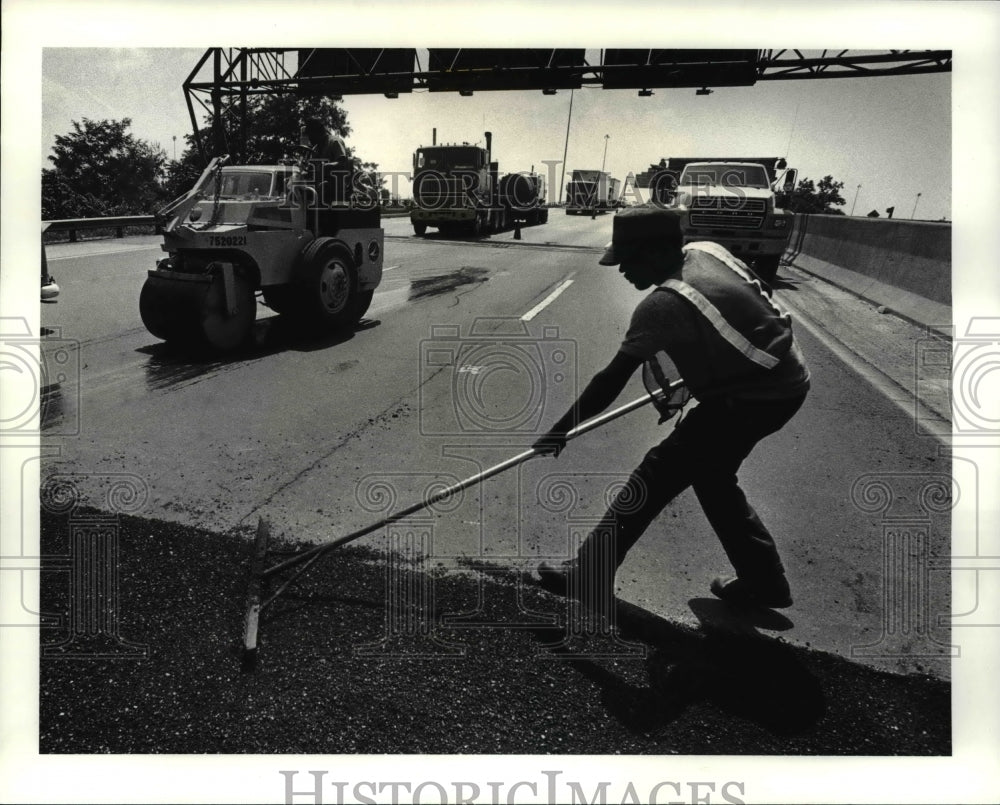 1987 Press Photo Patching with a rake on the interbelt streets and Highways. - Historic Images