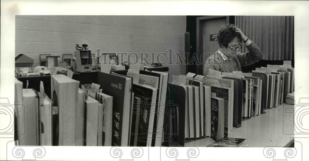 1984 Press Photo Lydia Champlin at Beechwood Middle School on long shelf of book- Historic Images