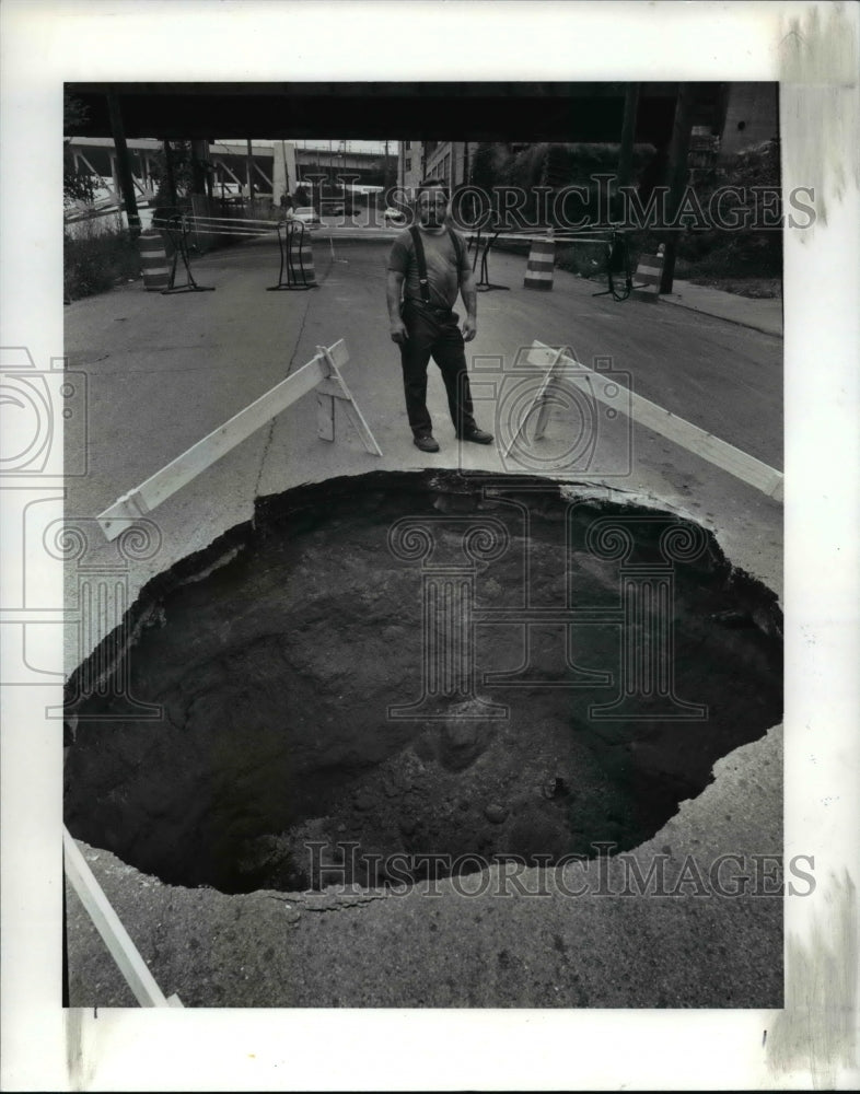 1990 Press Photo Otis Ferry Cap employee checking hole near plant- Historic Images